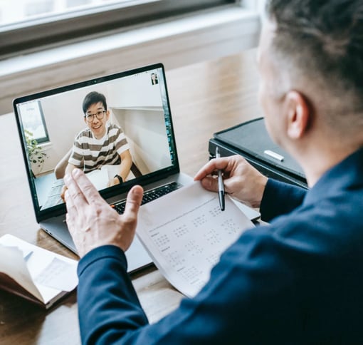 Photo of a man conducting a video meeting on his laptop